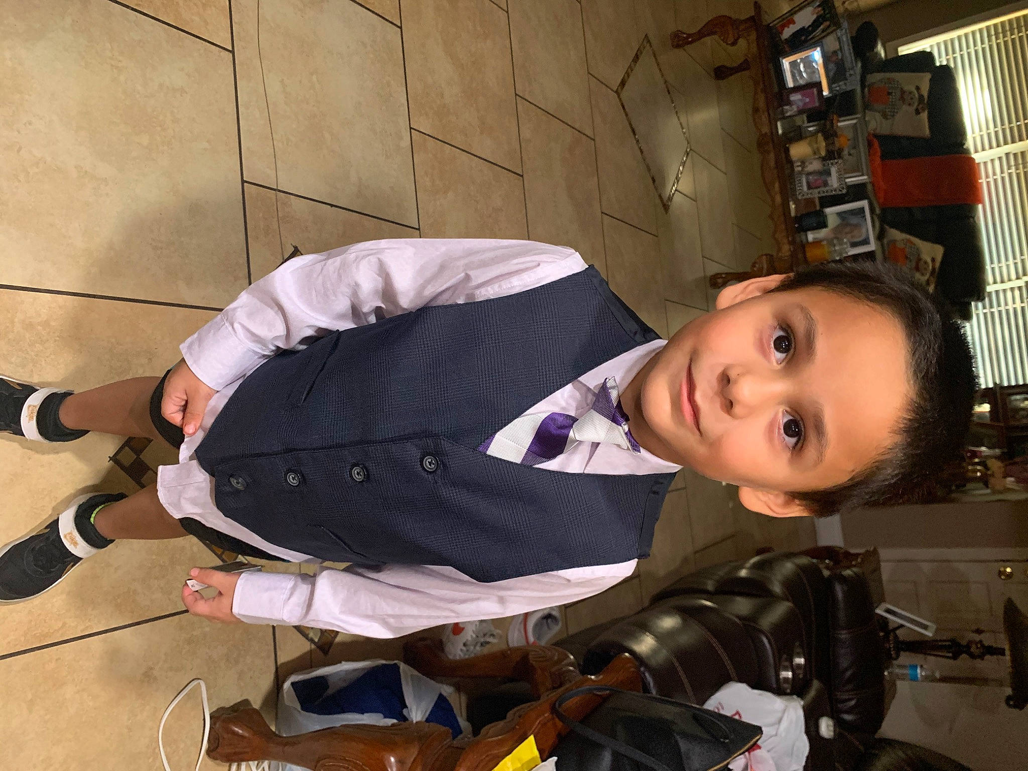 Julien is registered to the contest to win money with this photo: baby_carriage, baby_products, bookcase, child, flooring, fun, human_leg, joy, person, sandal, shelf, shoe, sitting, smile, sneakers, toddler