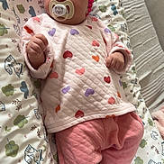 Maëlie participe au concours pour gagner de l'argent avec cette photo : baby, infant, pacifier, headband, pink, heart_pattern, clothing, lying_down, cushion, animal_print, fabric, footwearless, cute, indoors, sleepwear, child, soft_toys, blanket, relaxing, portrait