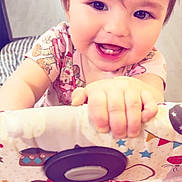 Hazel joined the competition — help win amazing prizes! baby, child, smiling, face, hand, teeth, playpen, pattern, clothing, indoor, cute, happy, infant, skin, toy, colorful, person, closeup, young, cheerful