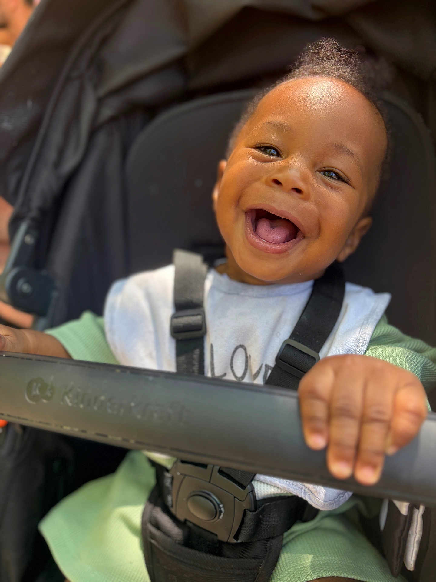 Mayvin participe au concours pour gagner de l'argent avec cette photo : toddler, smiling, child, stroller, baby, happy, seatbelt, clothing, hand, face, person, outdoor, baby_bib, closeup, infant, cute, portrait, daylight, black_hair, green_sleeves
