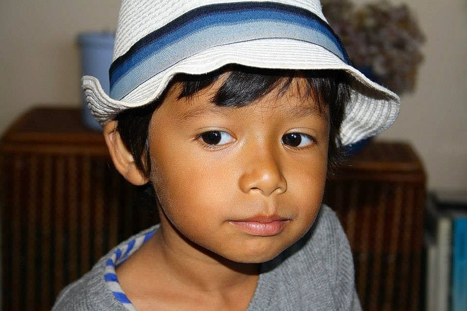 Tiago participe au concours pour gagner de l'argent avec cette photo : blue, bookcase, cap, child, electric_blue, eye, eyelash, face, fashion_accessory, fun, happy, hat, headgear, person, portrait_photography, smile, sun_hat, t_shirt, toddler