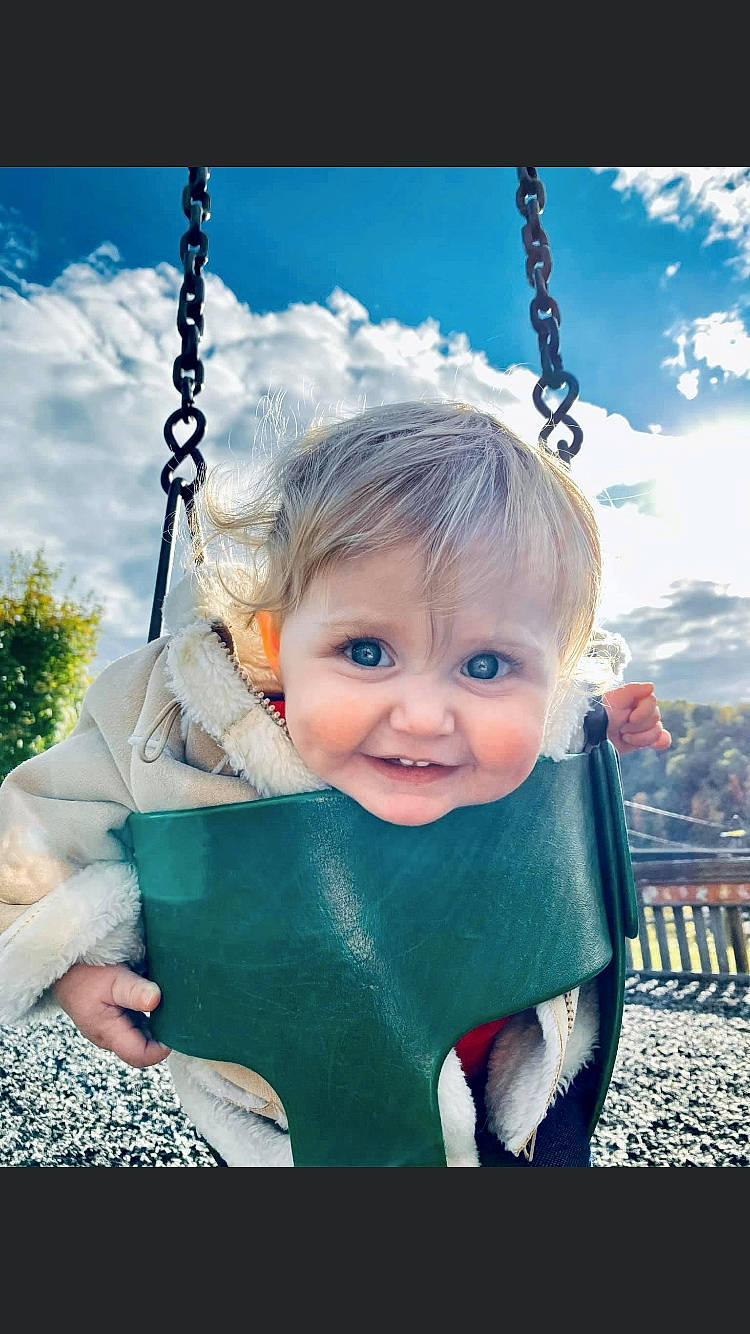 Aubree joined the competition — help win amazing prizes! baby, blond, child, eye, fun, happy, outdoor_play_equipment, person, photography, play, playground, portrait_photography, public_space, recreation, skin, sky, smile, stock_photography, swing, toddler