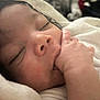 baby, sleeping, close_up, hand, blanket, newborn, face, peaceful, soft, infant, skin, mouth, wrapped, cute, child, resting, indoors, warm, tiny, portrait