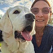 Angie participe au concours pour gagner de l'argent avec cette photo : dog, golden_retriever, person, woman, smiling, sunglasses, outdoor, sky, clouds, tongue_out, pet, happy, friendship, portrait, face, necklace, blue_shirt, daylight, nature, closeup