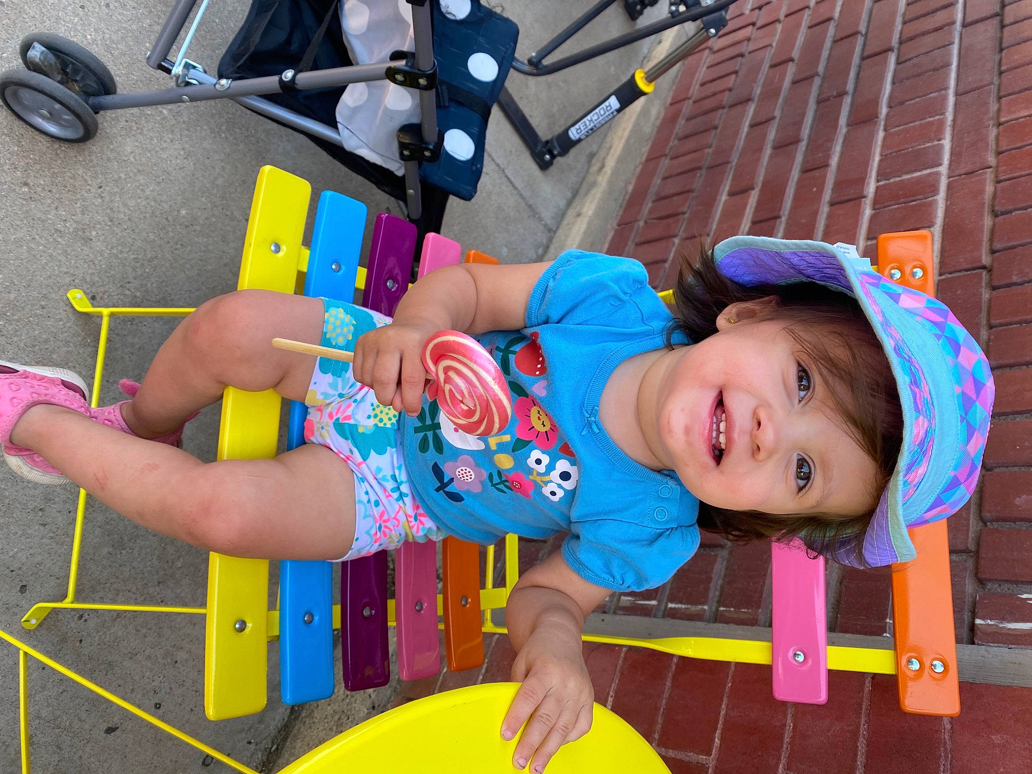 Imani is registered to the contest to win money with this photo: baby_toddler_clothing, blue, child, electric_blue, fun, happy, hat, headwear, joy, leisure, magenta, person, play, public_space, recreation, sandal, shorts, smile, t_shirt, toddler