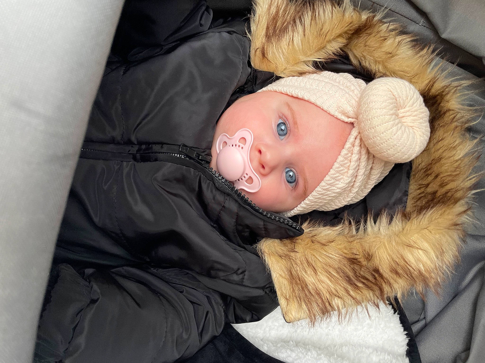 Lina participe au concours pour gagner de l'argent avec cette photo : animal_product, baby, beanie, cap, cheek, child, comfort, fur, fur_clothing, hat, headwear, jacket, knit_cap, natural_material, parka, person, toddler, toy, tree, winter