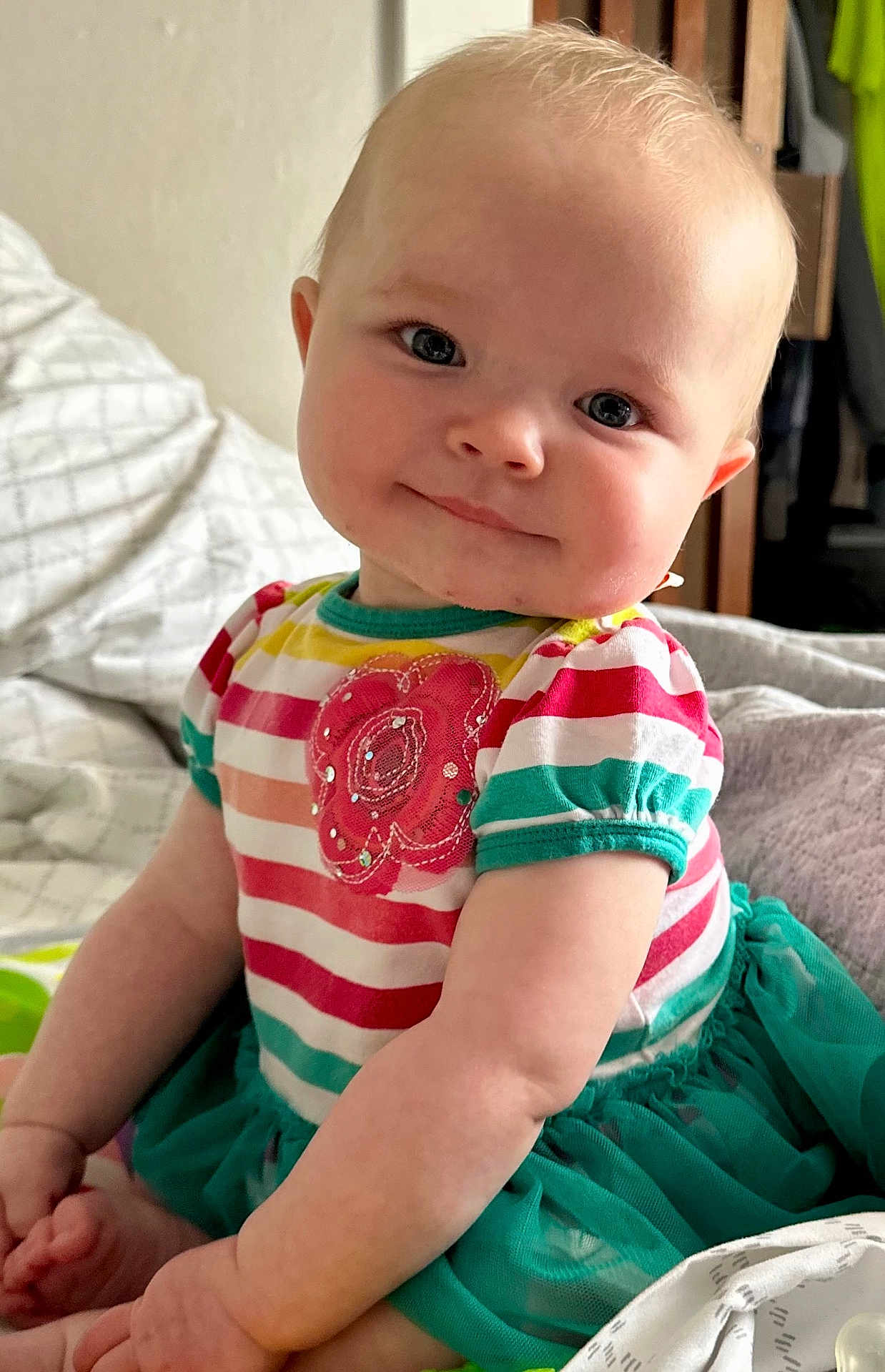 Berklee joined the competition — help win amazing prizes! baby, bed, blanket, child, clothing, cute, face, flower_applique, happy, head, indoor, infant, person, pillow, portrait, sitting, skin, smiling, striped_clothing, toddler
