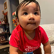 Natalia is registered to the contest to win money with this photo: toddler, child, baby, red_shirt, face, curious, indoors, home, furniture, flowers, portrait, person, skin, hair, eyes, hands, expression, couch, sitting, cute