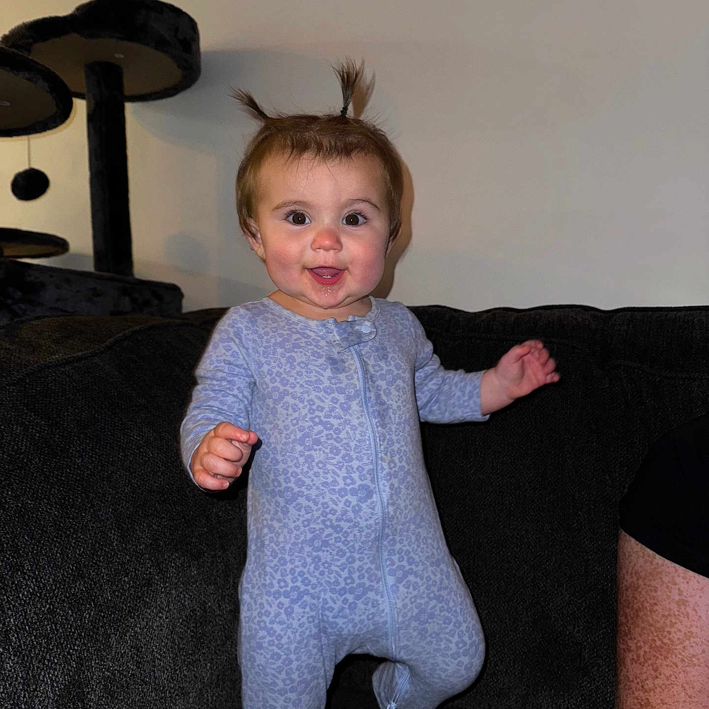 Alana Rae joined the competition — help win amazing prizes! baby, child, clothing, couch, cozy, cute, face, furniture, hair, happy, indoor, infant, living_room, onesie, person, playful, pony_tail, portrait, smiling, standing
