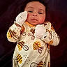 baby, infant, onesie, mittens, bee_pattern, lying_down, blanket, purple_background, cute, child, portrait, face, clothing, sleepwear, newborn, young_child, indoor, expression, person, soft_lighting