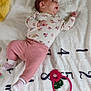 baby, infant, blanket, milestone_blanket, numbers, pink_pants, floral_shirt, socks, sloth_illustration, toy, lying_down, cute, child, portrait, soft_texture, indoor, colorful, expression, head, feet