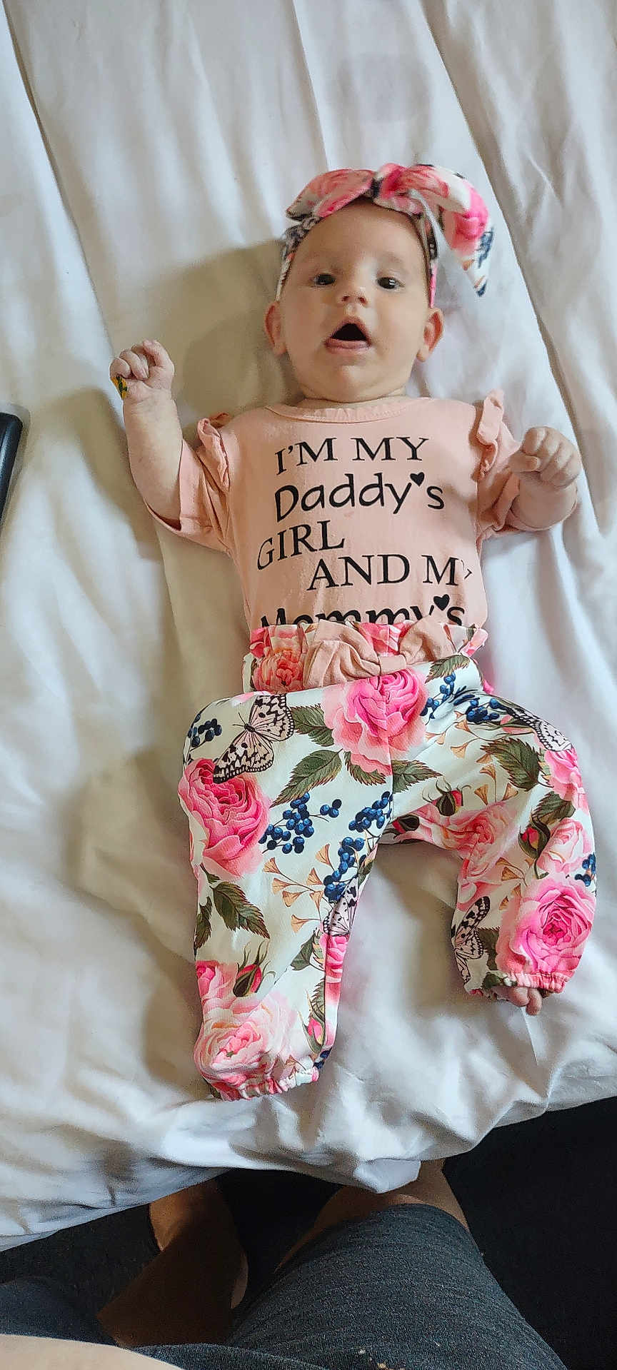 Makaylla joined the competition — help win amazing prizes! baby, child, infant, bed, bedding, headband, floral, pants, shirt, text, person, lying_down, cute, pink, flower, pattern, open_mouth, indoors, fabric, sleepwear