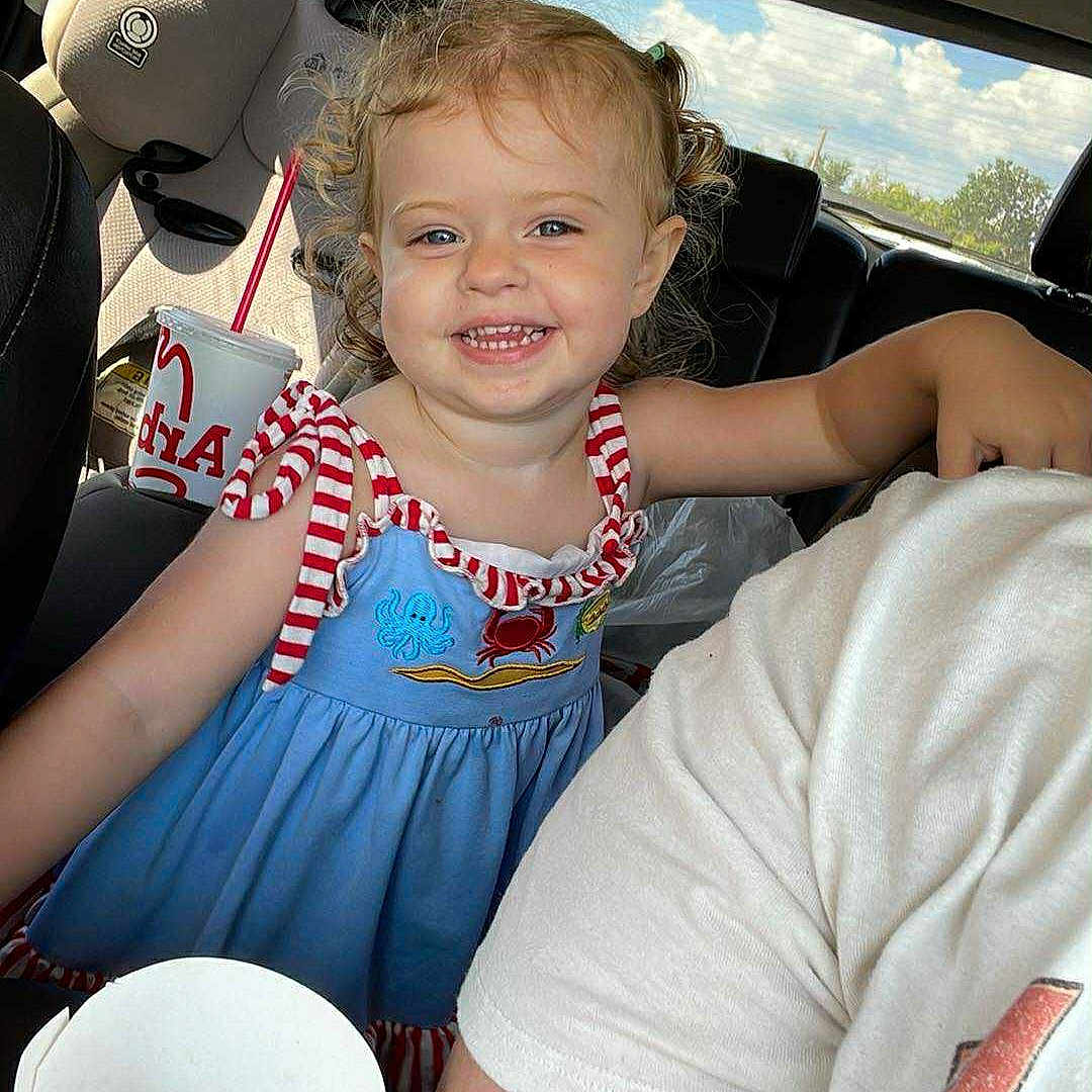 Izabella joined the competition — help win amazing prizes! arm, blue_dress, car_interior, casual_clothing, child, clouds, curly_hair, drink_cup, fast_food, fries_container, happy, person, portrait, red_stripes, seat, sky, smiling, sunlight, toddler, window