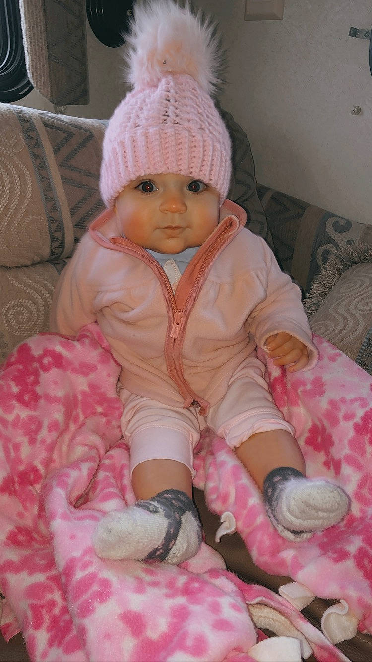 Brogan joined the competition — help win amazing prizes! baby, baby_toddler_clothing, beanie, bonnet, child, child_model, comfort, costume_accessory, couch, headband, headwear, knit_cap, knitting, lap, living_room, peach, person, pink, sock, toddler