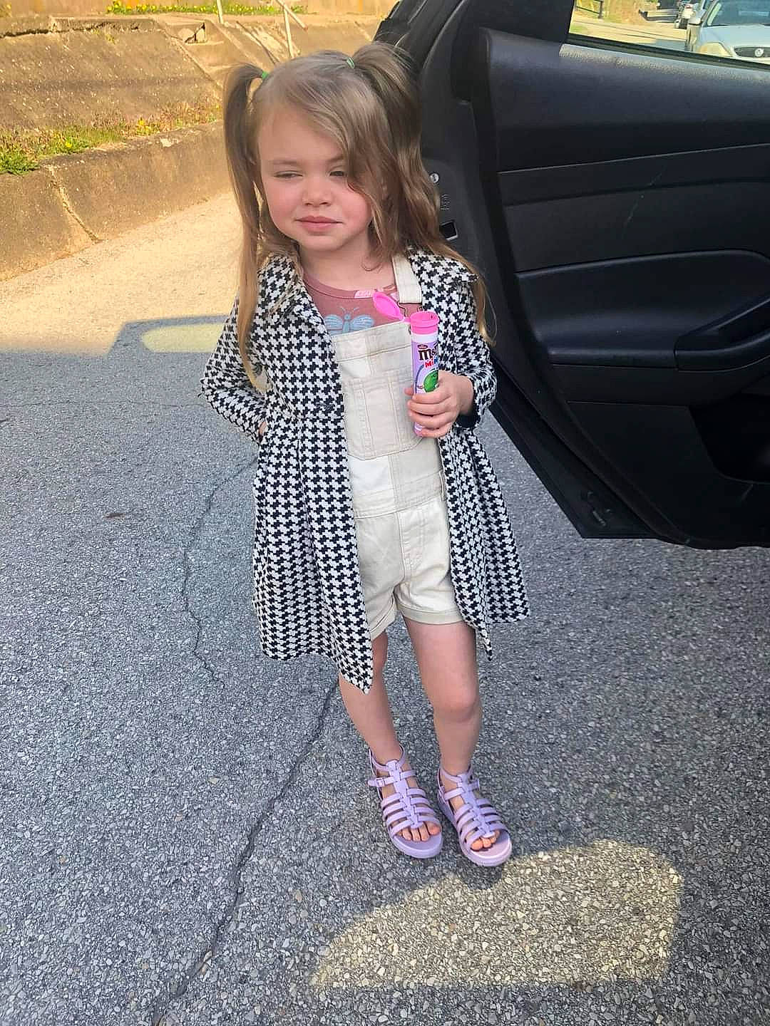 Alexandria is registered to the contest to win money with this photo: asphalt, automotive_design, automotive_exterior, automotive_lighting, automotive_tire, bumper, door, dress, grass, leg, motor_vehicle, person, plant, road_surface, sidewalk, sneakers, tire, toddler, trunk, vehicle_door