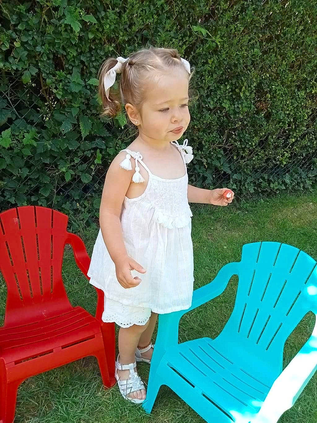 Lexie participe au concours pour gagner de l'argent avec cette photo : baby_toddler_clothing, chair, comfort, day_dress, dress, event, furniture, grass, green, hair, hairstyle, happy, head, lap, leisure, outdoor_furniture, pattern, person, plant, sitting