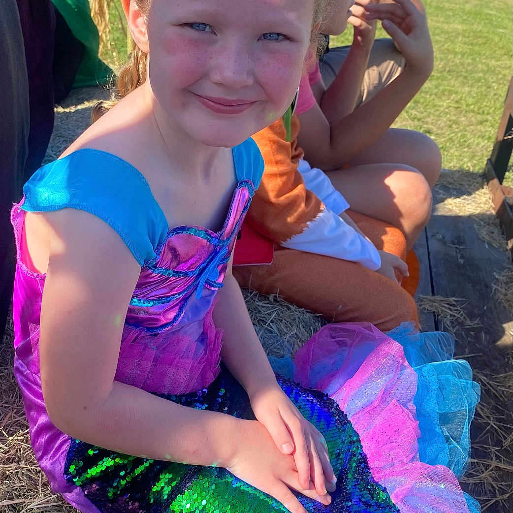 Aubree Blair is registered to the contest to win money with this photo: accessories, baby, child, clothing, costume, dress, face, female, girl, grass, head, jewelry, nature, outdoors, person, photography, plant, portrait, purple, soil