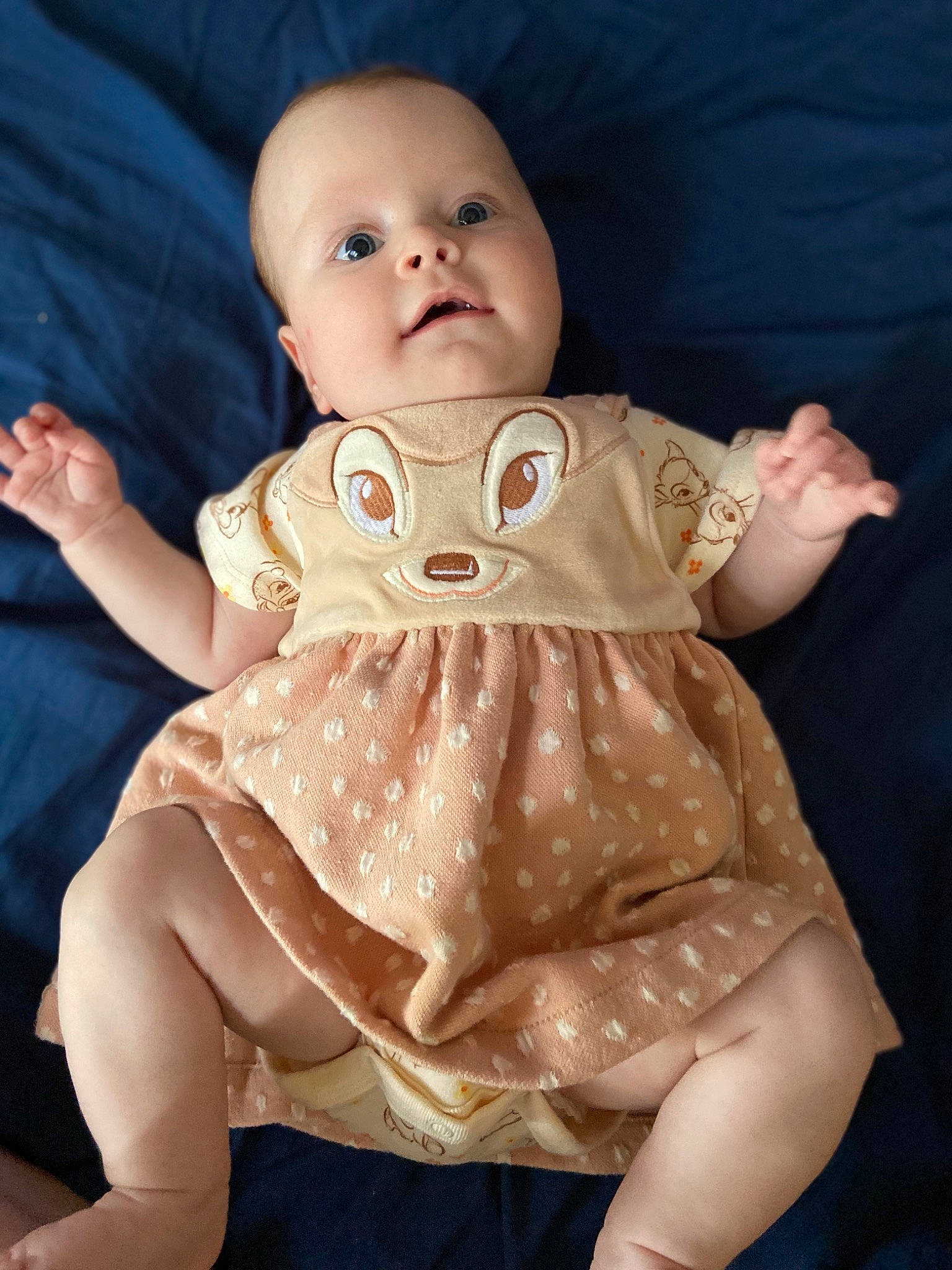 Kiera is registered to the contest to win money with this photo: baby, beige, cheek, child, dress, eye, hand, head, person, sitting, skin, smile, toddler, toy