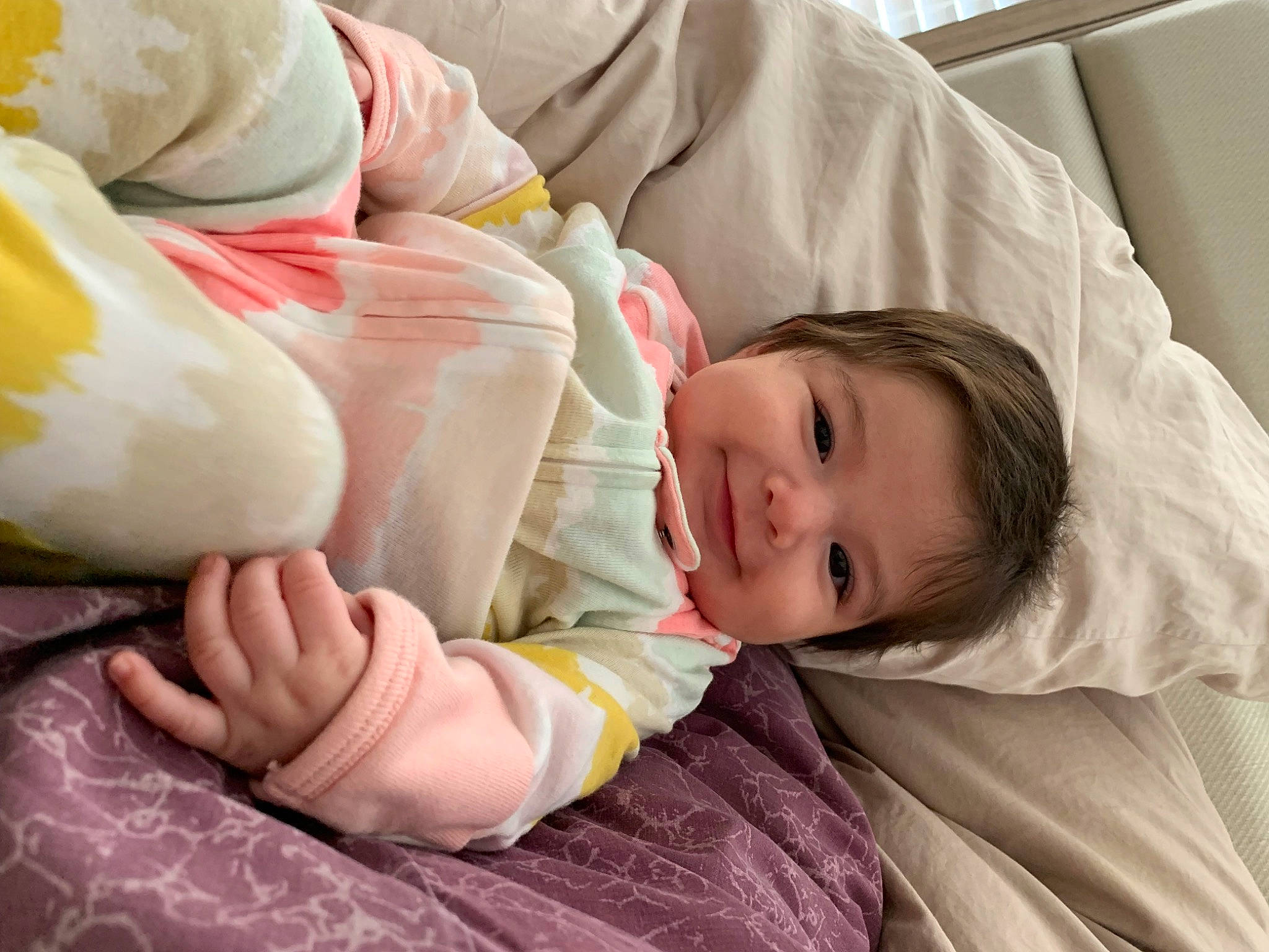 Julianna is registered to the contest to win money with this photo: baby, baby_toddler_clothing, bedding, bedtime, cheek, child, comfort, facial_expression, foot, gesture, happy, joy, linens, nail, nap, person, room, sitting, skin, sleep