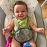 Luna joined the competition — help win amazing prizes! baby, child, smile, happy, sitting, baby_seat, toy, pony, hair_clip, green_clothing, indoors, floor, wood_floor, straps, face, person, cute, infant, playful, colorful