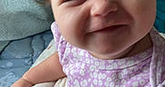 Luna is registered to the contest to win money with this photo: baby, child, smile, purple_clothing, blanket, indoor, curtains, face, hair, toddler, sitting, happy, soft_texture, infant, closeup, cute, person, childhood, candid, natural_light