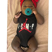Heiress joined the competition — help win amazing prizes! baby, infant, pacifier, headband, red_bow, onesie, black_clothing, lying_down, blanket, cute, child, adorable, infant_clothing, young_child, relaxed, indoors, soft_texture, skin, small_hands, small_feet