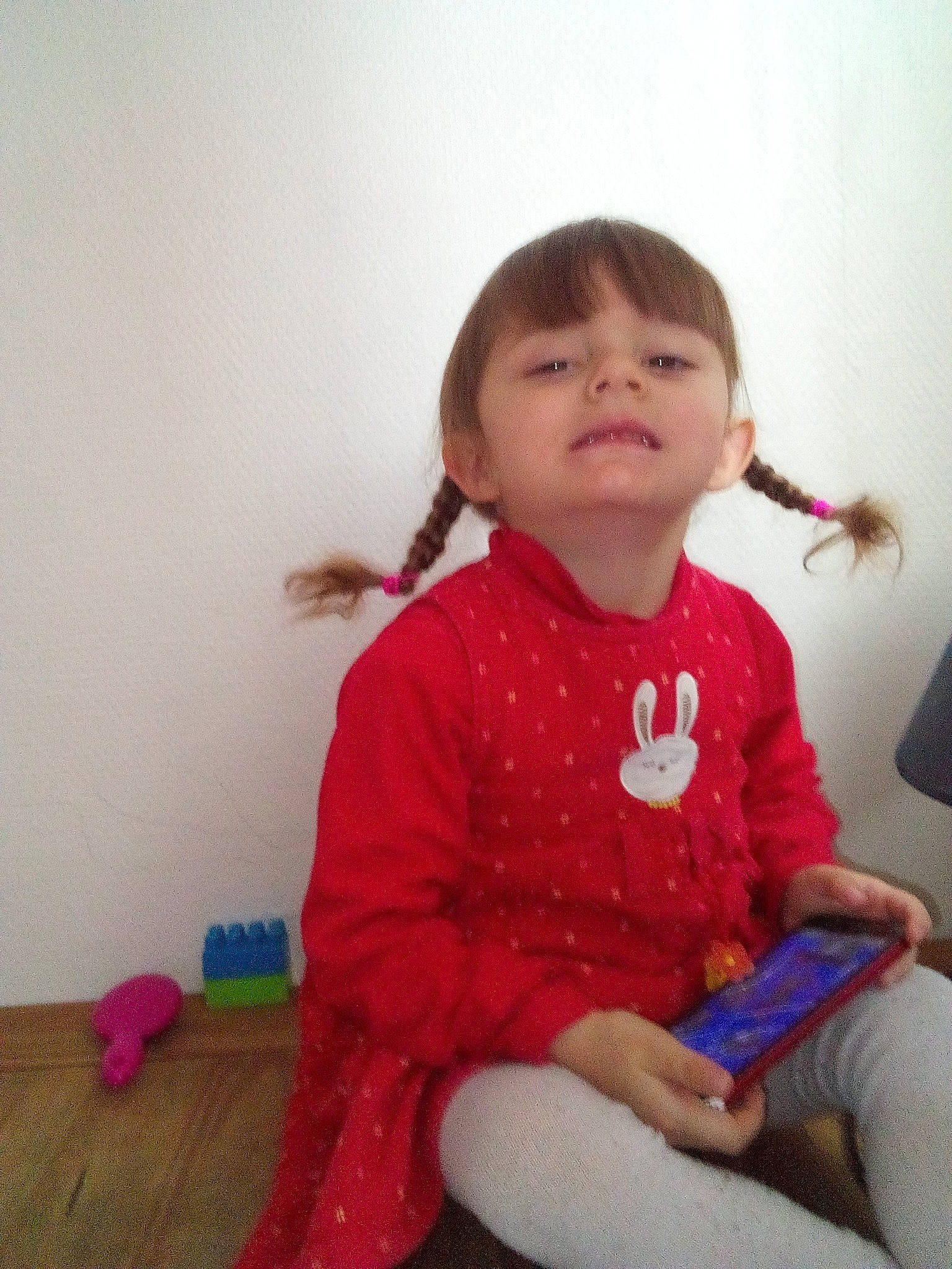 Lindsay participe au concours pour gagner de l'argent avec cette photo : baby_toddler_clothing, cheek, child, face, flooring, fun, happy, hardwood, iris, knee, magenta, pattern, person, sitting, skin, sleeve, smile, sock, t_shirt, toddler