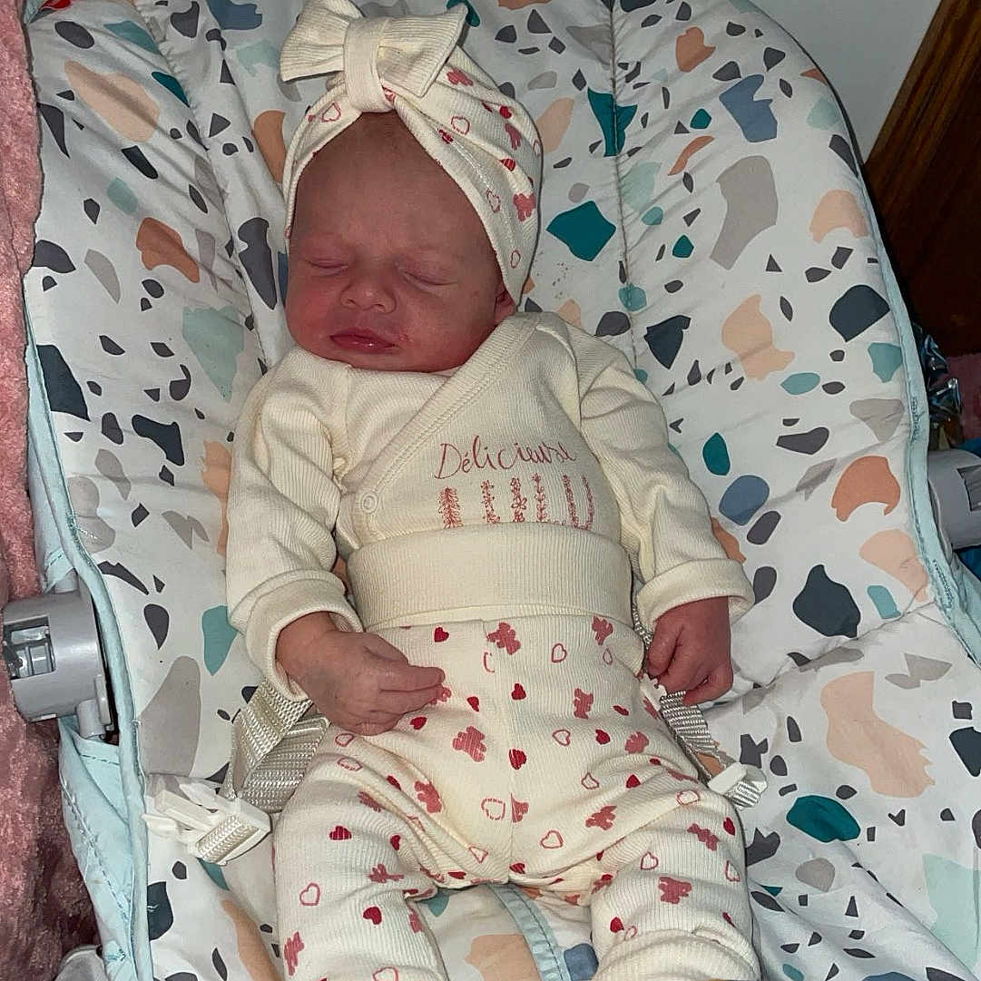 Yuna participe au concours pour gagner de l'argent avec cette photo : newborn, baby, sleeping, infant, headband, clothing, baby_rocker, patterned, cozy, child, indoors, cute, small, resting, soft, wearing, person, adorable, comfort, peaceful