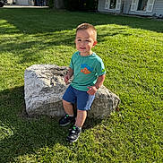 Isaiah joined the competition — help win amazing prizes! toddler, child, boy, rock, grass, tree, sunlight, outdoor, greenery, shorts, tshirt, shoes, sidewalk, house, window, curious, nature, daylight, portrait, playful