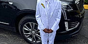 Antwon joined the competition — help win amazing prizes! child, boy, white_suit, tie, sunglasses, car, black_suv, pavement, parking_lot, ribbon, formal_wear, shoes, urban, outdoor, portrait, standing, person, vehicle, tire, headwear