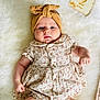 Agathe a rejoint le concours — aidez-le/la à gagner de superbes lots ! baby, infant, headband, dress, floral_pattern, blanket, cute, fist, lying_down, soft_texture, skin, child, portrait, indoor, adorable, young, small_hands, clothing, comfortable, peaceful