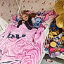 bed, bedroom, birds, blanket, butterflies, cartoon_character, child, cozy, furniture, girl, happy, home, indoor, pillow, pink, plush_toys, sleepwear, smiling, toy, wallpaper