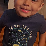 Jonathan joined the competition — help win amazing prizes! child, boy, toddler, portrait, smiling, happy, indoors, standing, t_shirt, graphic_shirt, short_hair, blond_hair, face, eyes, mouth, wooden_floor, furniture, home, photography, close_up