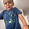 child, toddler, boy, portrait, face, smiling, indoors, home, blue_shirt, t_shirt, graphic_shirt, bird_design, beach_design, wooden_railing, hand, short_hair, brown_hair, looking_at_camera, standing, family_photo