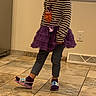 Alianna is registered to the contest to win money with this photo: child, toddler, girl, portrait, standing, smiling, indoors, home, tutu, skirt, striped_shirt, owl_shirt, purple_clothing, leggings, slippers, tile_floor, window, blinds, electrical_outlet, playful
