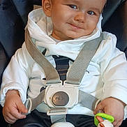 Kélyan a rejoint le concours — aidez-le/la à gagner de superbes lots ! toddler, child, smile, car_seat, safety_harness, hoodie, toy, indoor, person, cute, happy, baby, seat, clothing, face, hand, playful, young_child, straps, portrait