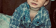Kélyan a rejoint le concours — aidez-le/la à gagner de superbes lots ! toddler, child, boy, cap, plaid_shirt, sneakers, sitting, indoor, blanket, curious, cute, young, face, hands, footwear, clothing, person, expression, casual, portrait