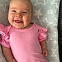 baby, smiling, infant, pink_clothing, blanket, stars_pattern, happy, face, lying_down, cute, child, soft_texture, portrait, skin, hand, head, cheeks, person, toddler, indoors