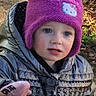 child, toddler, hat, hello_kitty, jacket, outdoor, autumn, leaves, blue_eyes, curious, cold_weather, knit_hat, nature, person, portrait, winter_clothing, young_child, cute, exploring, daylight