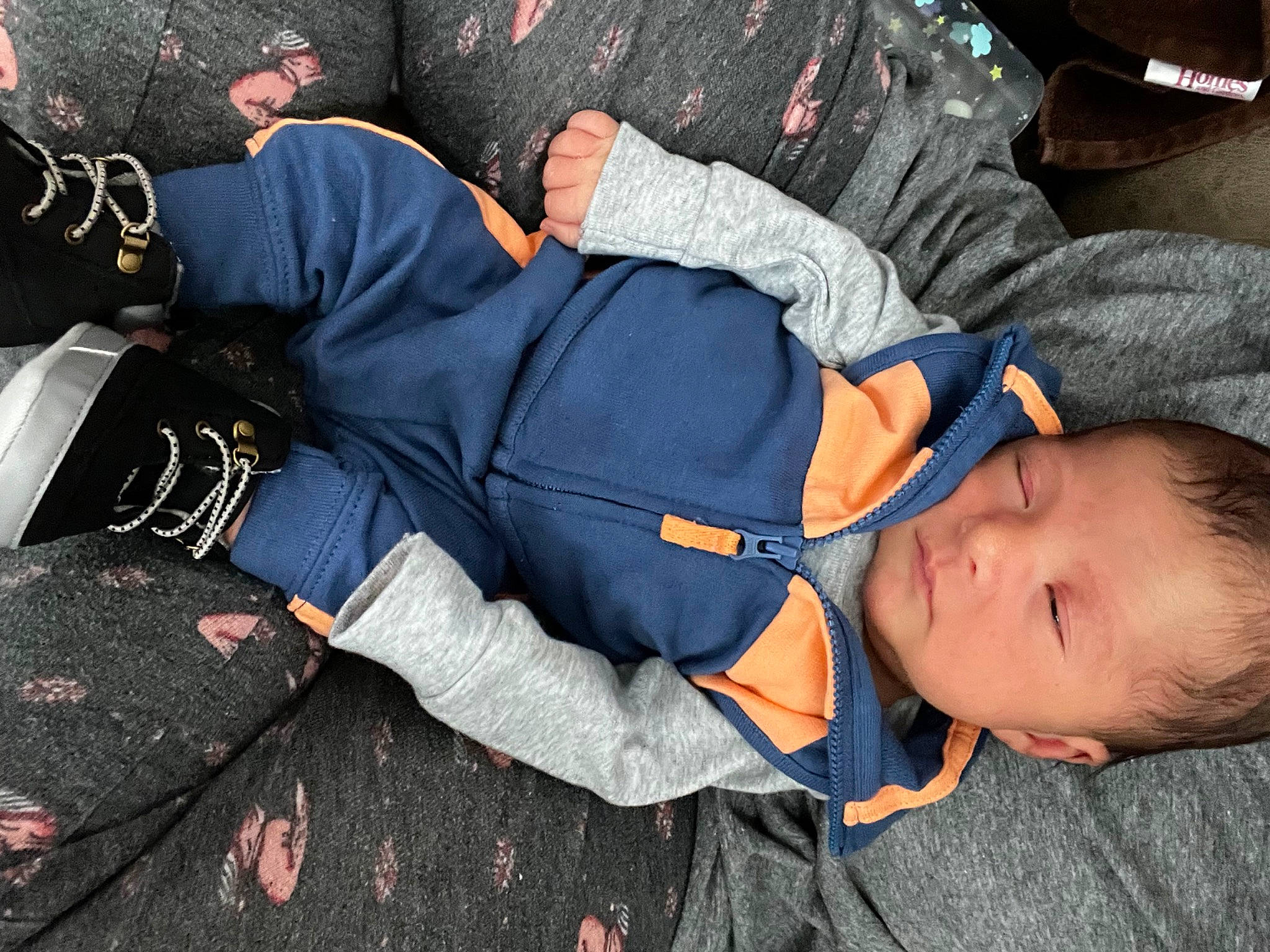 Jaxton is registered to the contest to win money with this photo: arm, baby_toddler_clothing, child, comfort, elbow, gesture, glove, hand, hat, joint, pattern, person, sitting, sleep, sleeve, smile, t_shirt, thigh, toddler, uniform