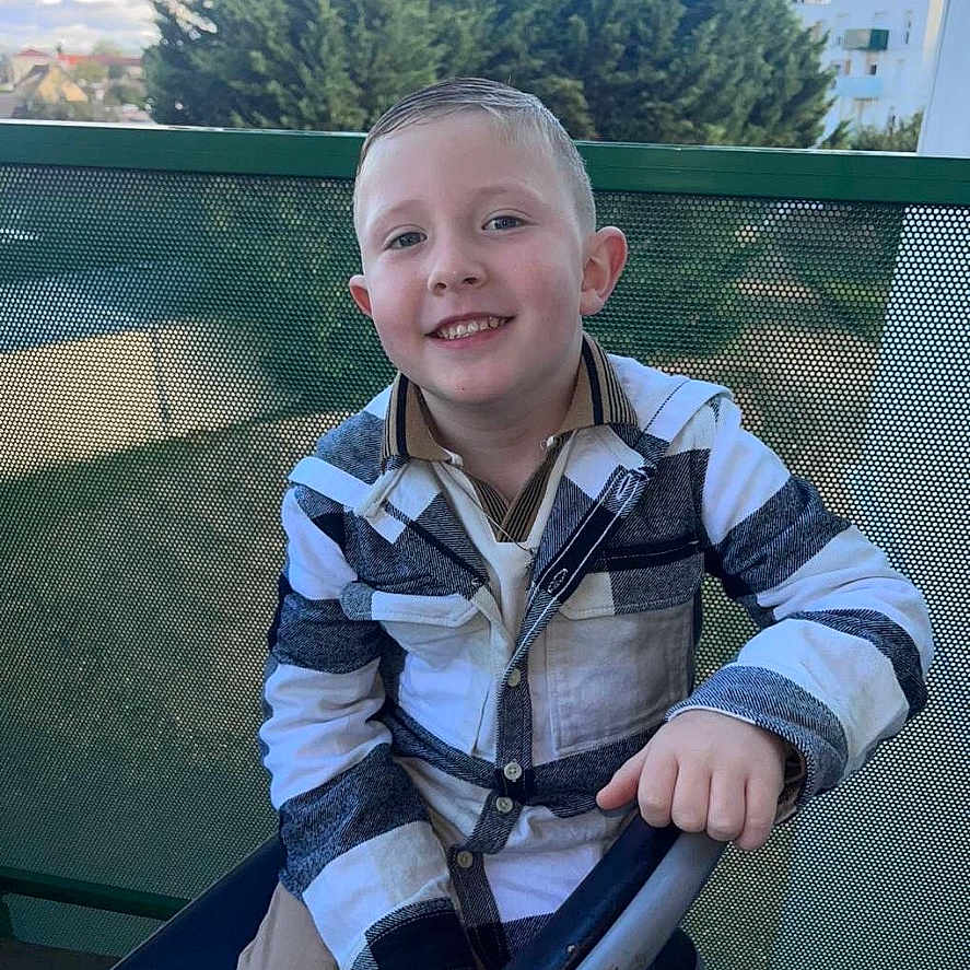 Liam participe au concours pour gagner de l'argent avec cette photo : boy, child, city, clothing, coat, face, grass, happy, head, jacket, male, outdoors, pants, person, photography, plant, playarea, portrait, smile, tree