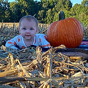 Evaleighn is registered to the contest to win money with this photo: baby, pumpkin, pumpkin_patch, outdoor, fall, autumn, field, nature, child, forest, blue_sky, blanket, cute, person, smiling, harvest, seasonal, young_child, crawling, daylight