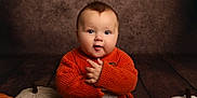 Arthur joined the competition — help win amazing prizes! baby, child, infant, orange_sweater, knitwear, pumpkin, fabric_pumpkin, fall, autumn, cute, portrait, smiling, hands, floor, wood, background, studio, cozy, warm, indoor