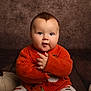 baby, child, infant, orange_sweater, knitwear, pumpkin, fabric_pumpkin, fall, autumn, cute, portrait, smiling, hands, floor, wood, background, studio, cozy, warm, indoor