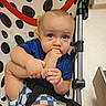 Noah joined the competition — help win amazing prizes! baby, child, infant, stroller, seated, blue_shirt, checkered_shorts, polka_dot_pattern, buckle, harness, finger_sucking, curious, portrait, indoors, floor, metal_frame, closeup, blond_hair, blue_eyes, photography
