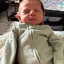 newborn, baby, infant, sleeping, onesie, clothing, face, head, hand, indoor, living_room, crib, furniture, soft_light, peaceful, child, person, portrait, cozy, resting