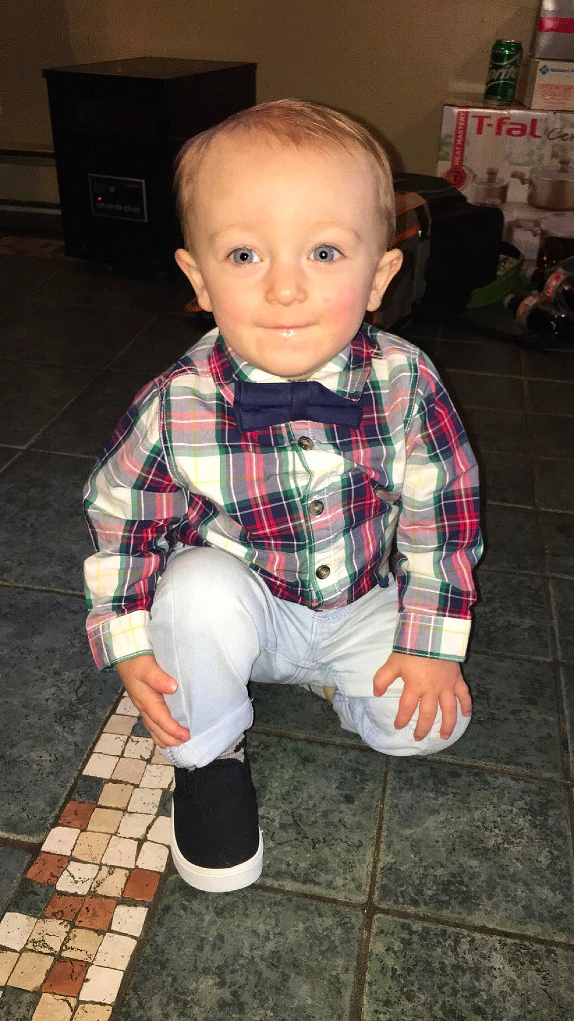 Travis is registered to the contest to win money with this photo: baby, cheek, child, design, flooring, pattern, person, plaid, sitting, tartan, textile, toddler