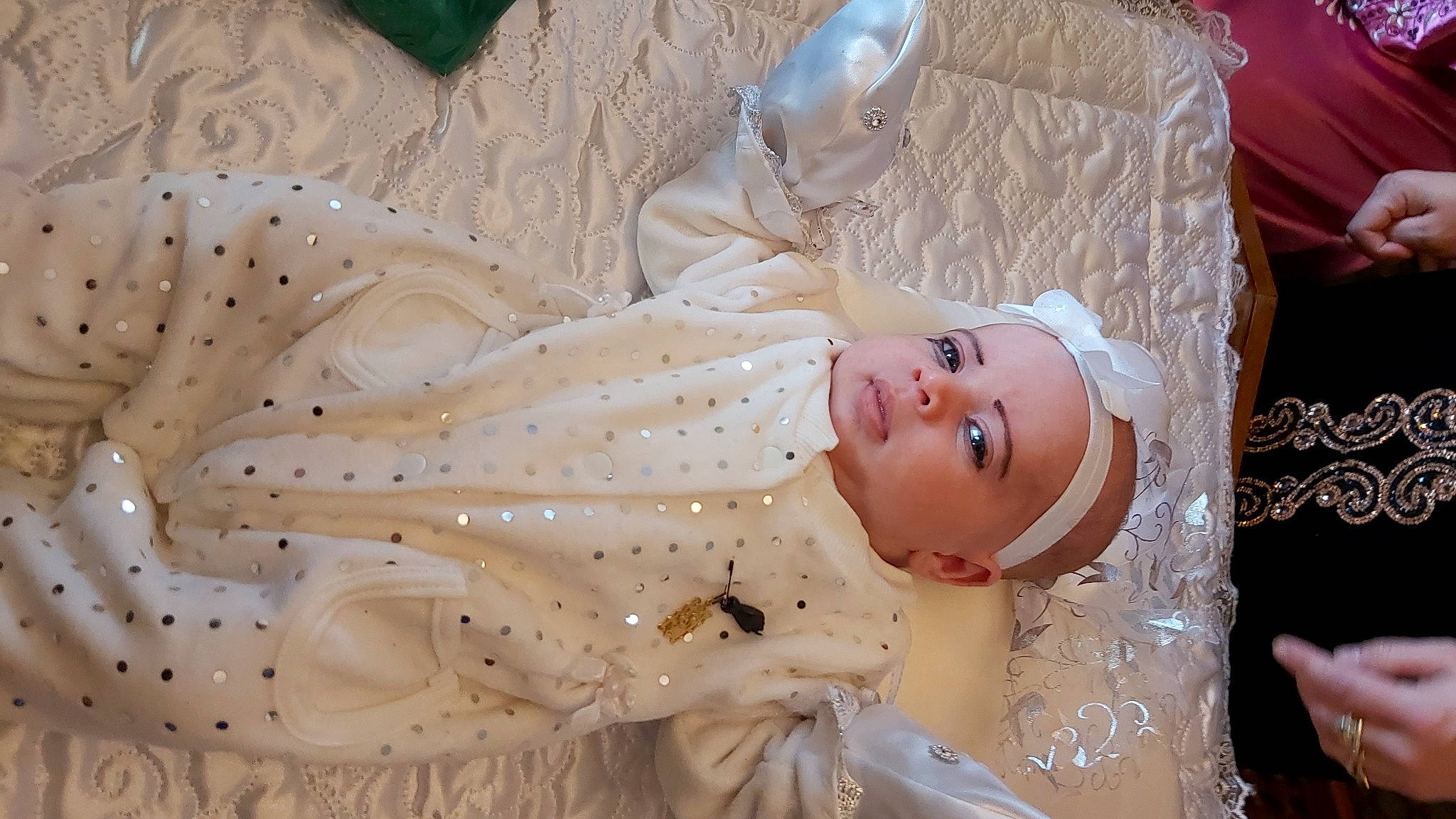 Eline a rejoint le concours — aidez-le/la à gagner de superbes lots ! baby, bridal_accessory, child, dress, embellishment, event, eyelash, hand, happy, head, headpiece, human_body, jewellery, pattern, peach, person, pink, skin, smile, textile