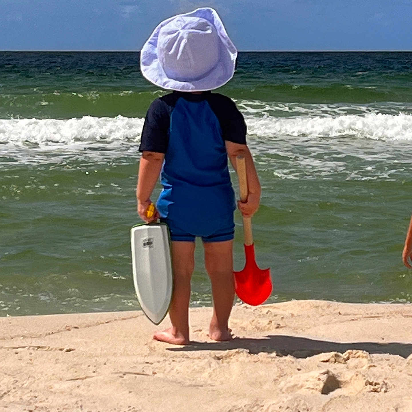 Asher is registered to the contest to win money with this photo: back_view, barefoot, beach, blue_sky, child, holiday, ocean, outdoor, playtime, sand, sand_castle_tools, sand_sifter, shore, shovel, sky, summer, sunhat, vacation, water, waves