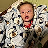 Karsten joined the competition — help win amazing prizes! baby, infant, child, portrait, face, eyes, surprised, blanket, teddy_bear_pattern, red_shirt, bed, crib, indoor, cozy, lying_down, close_up, head, hair, photography, home